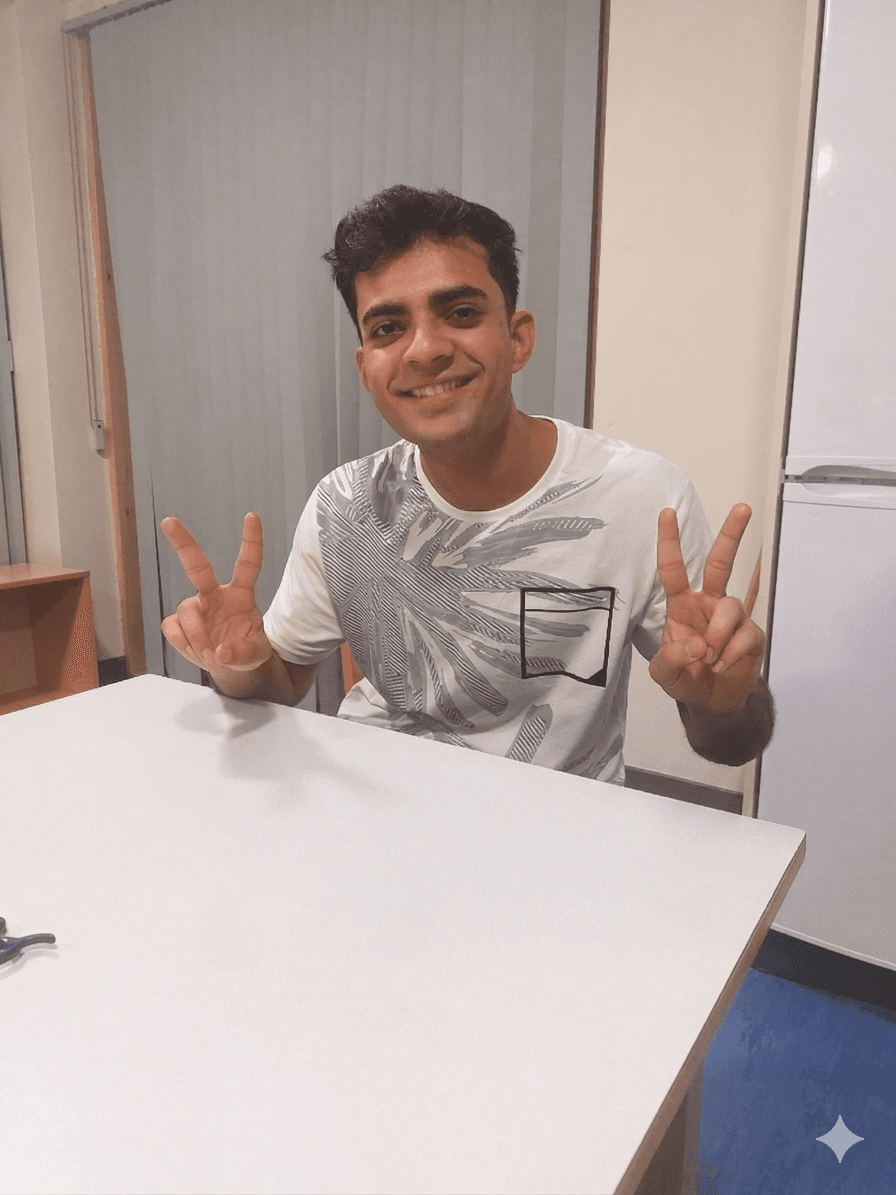 Harshit sitting behind a laptop and smiling